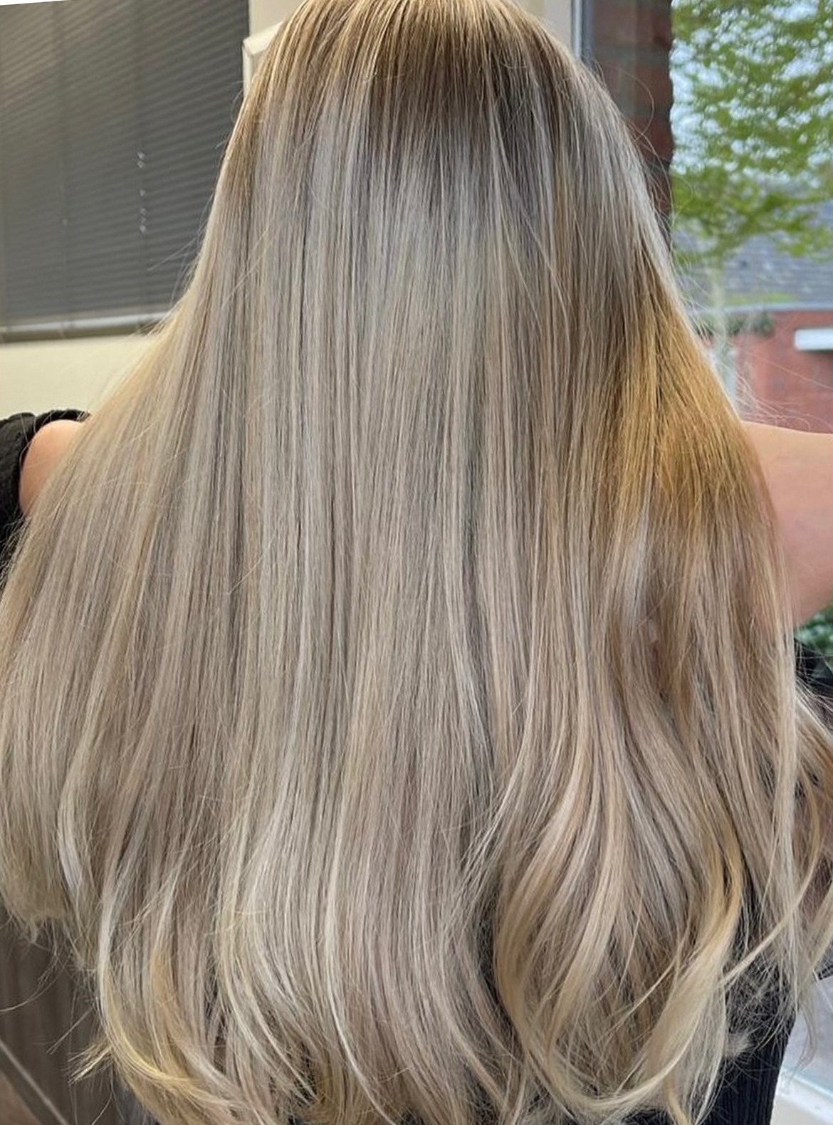 Lang, steil blond haar met zachte highlights, van achteren gezien