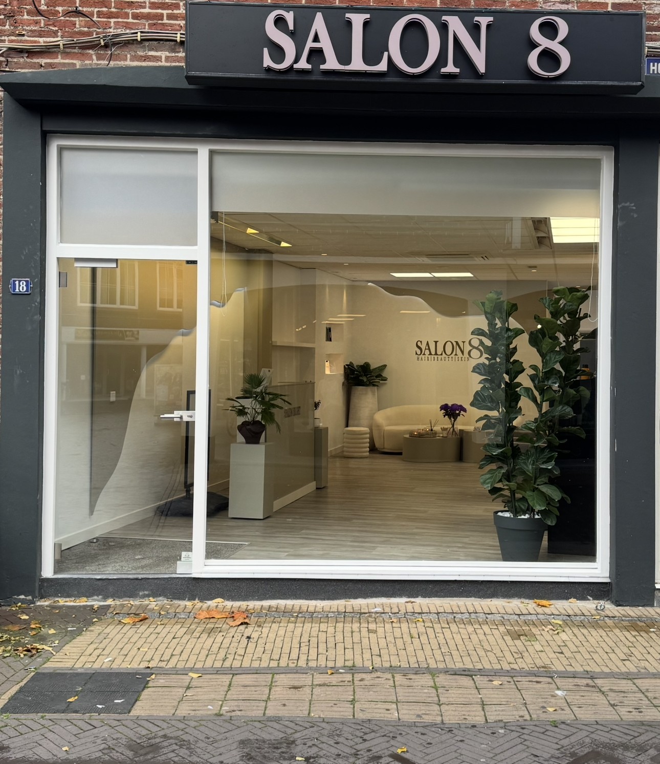 De gevel van Salon8 aan de Hoogstraat met SALON 8 boven het grote raam